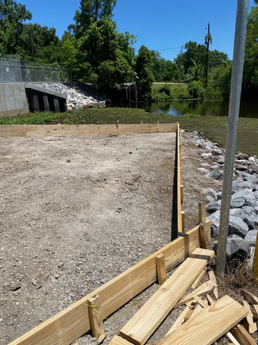 Timber slab forms beside a stone embankment
