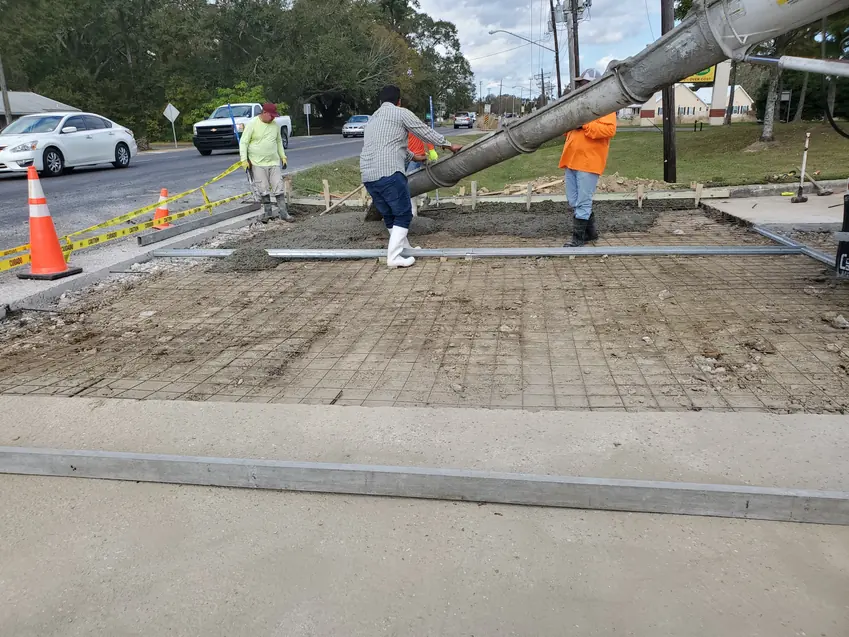 Crew placing concrete from a mixer chute over reinforcement